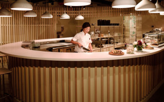 An Asian chef preparing a dessert for customers